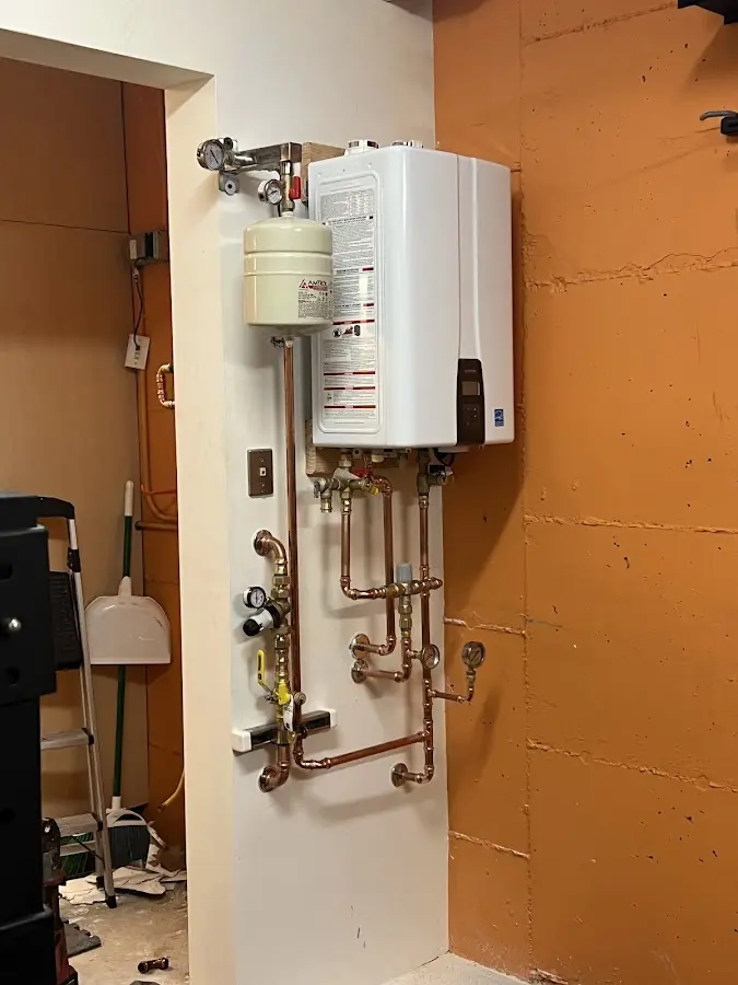 Plumbing technician inspecting water heater connections in Waverly